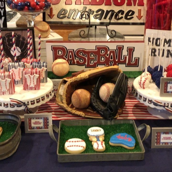 Baseball themed party table with themed cookies, a leather glove, and baseball decorations.