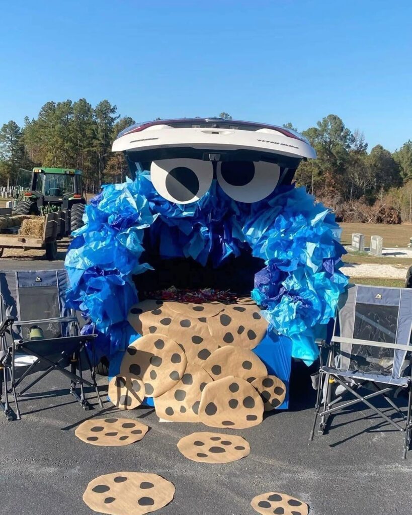White car trunk decorated as Cookie Monster with blue ruffles and cardboard cookies.