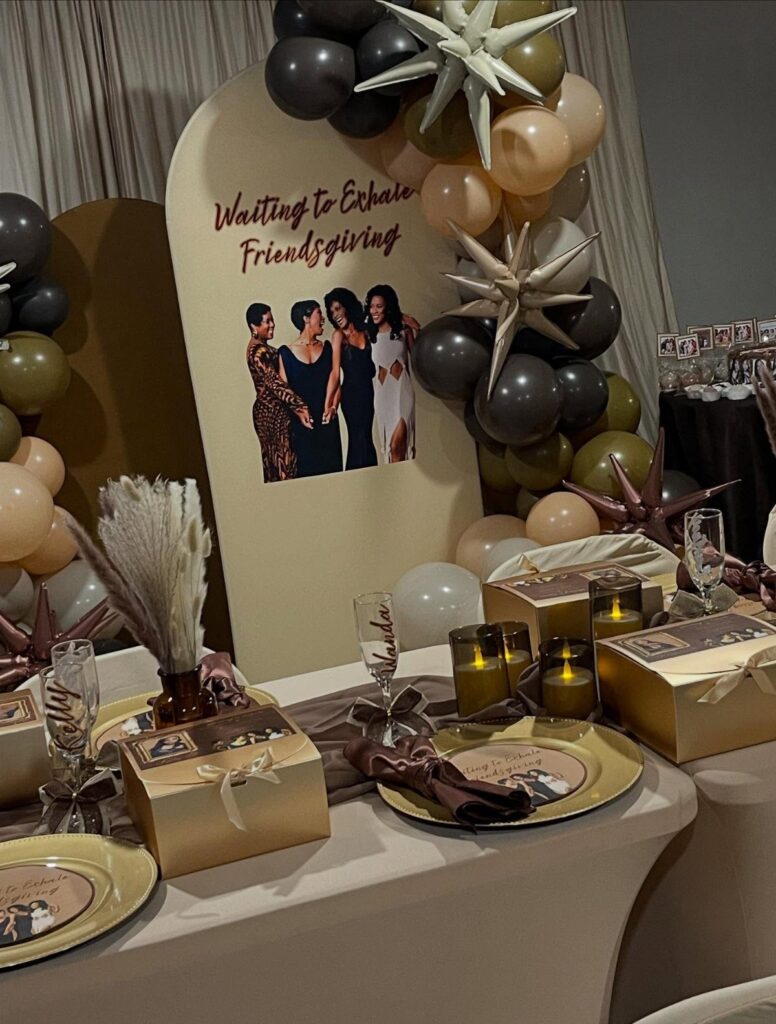 Decorated Friendsgiving table with gold accents, balloons, and a personalized event backdrop.