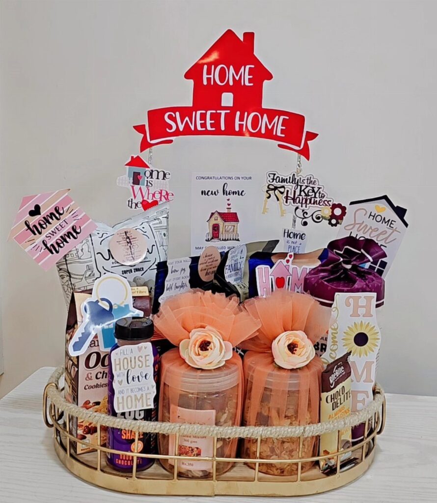 Housewarming gift basket with snacks, jars, and Home Sweet Home decorations in a tray