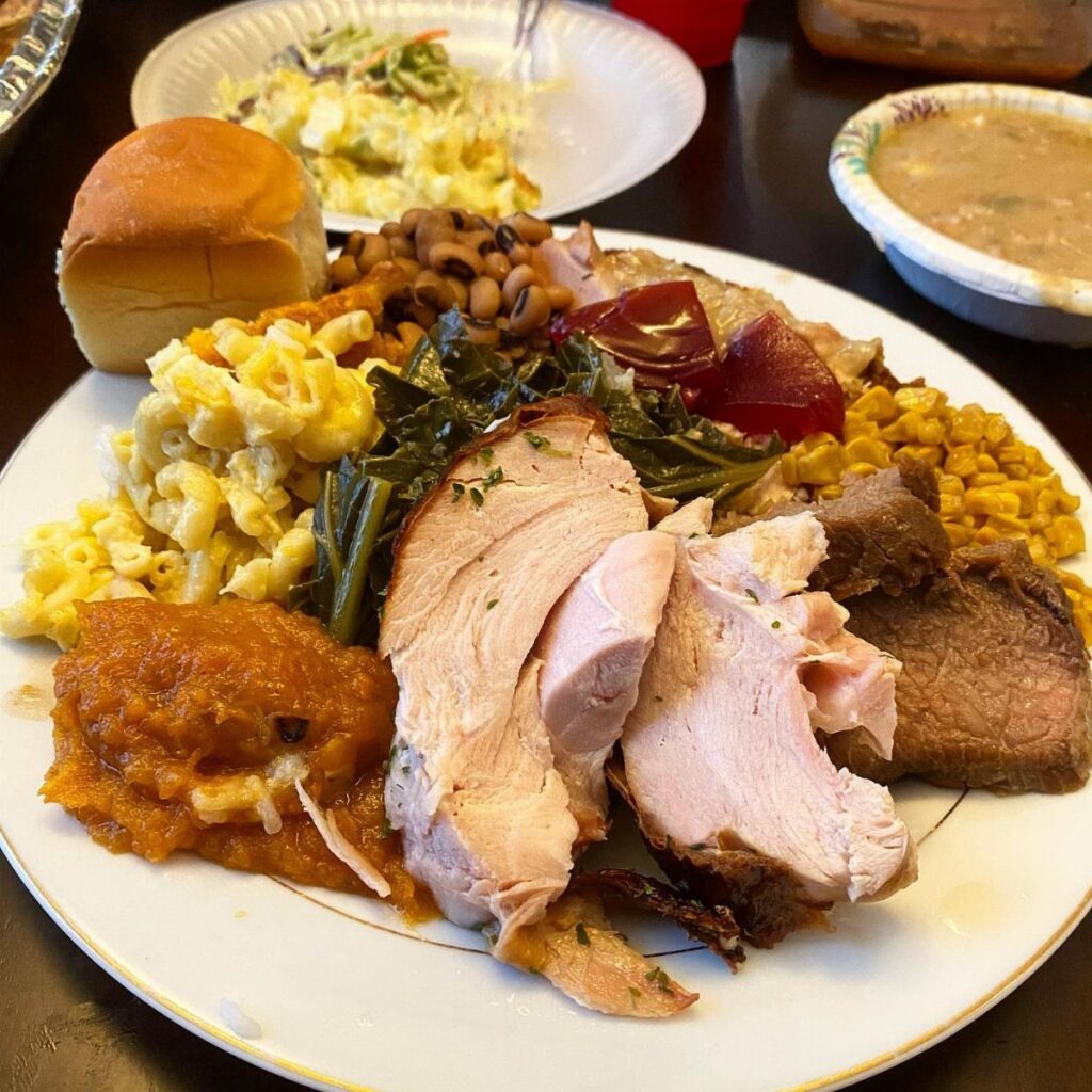 Platter of roasted turkey, beef, macaroni and cheese, and various vegetable side dishes.