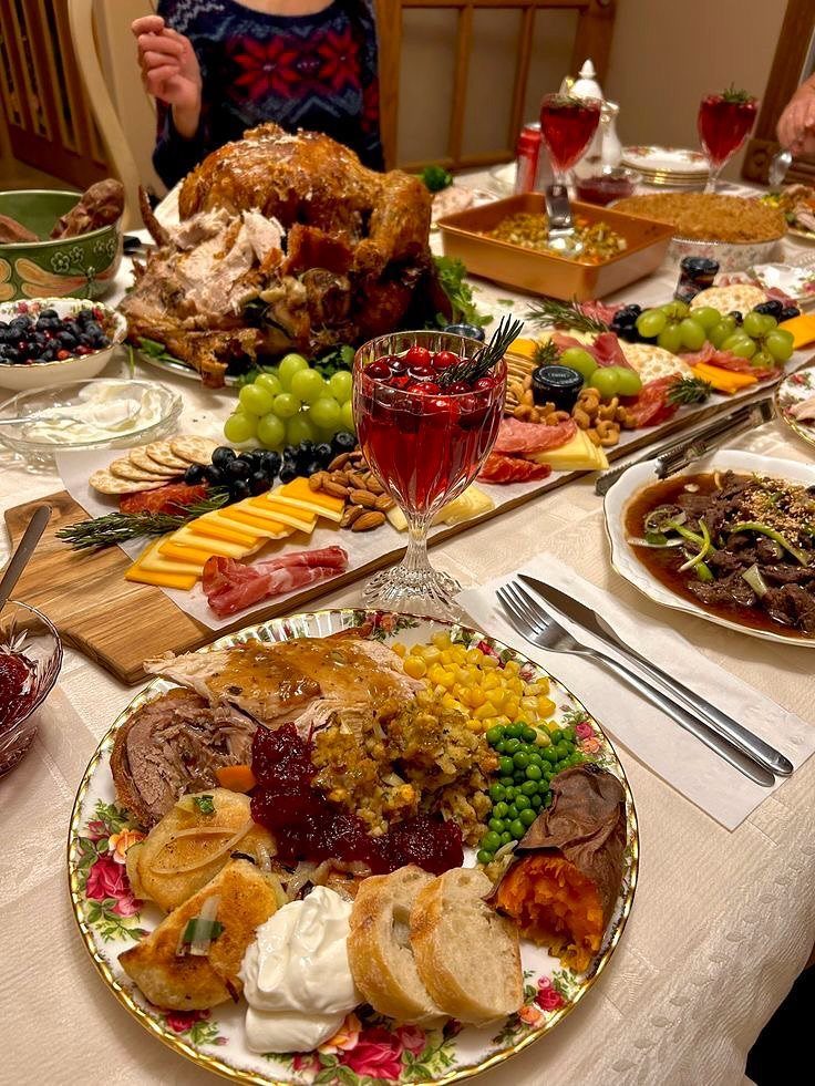 Roasted turkey and festive side dishes spread across a decorated Thanksgiving dinner table